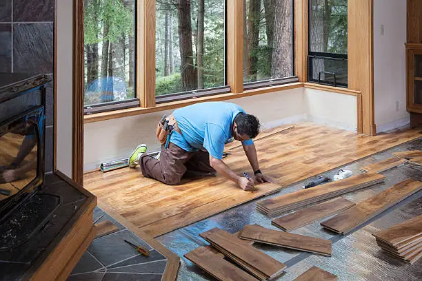 Laminate Flooring Installation in Coeur d'Alene - ID in progress as a crew fits planks near a fireplace