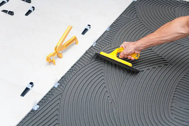 Installer checking spacing during Tile Installation in a Post Falls - ID bathroom renovation